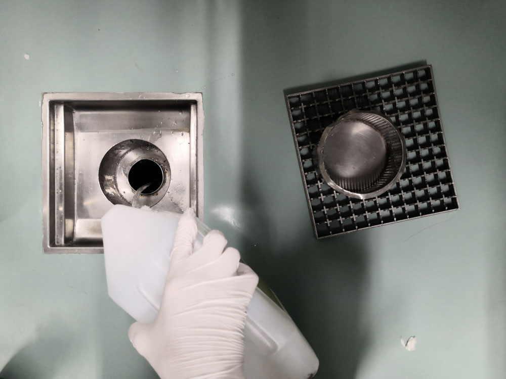 person using chemical cleaners on drains