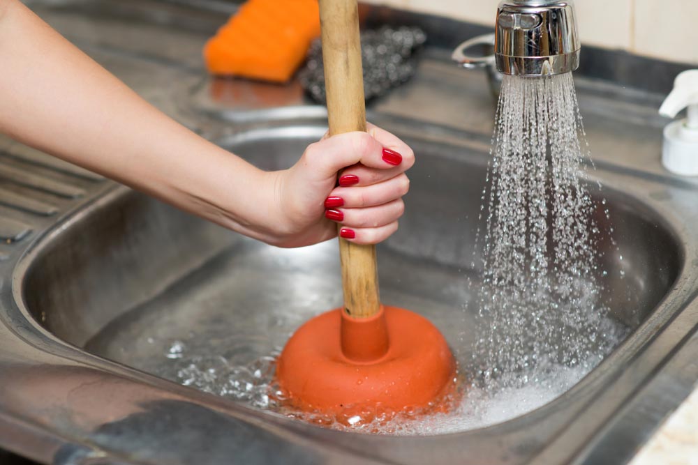 homeowner plunging a drain